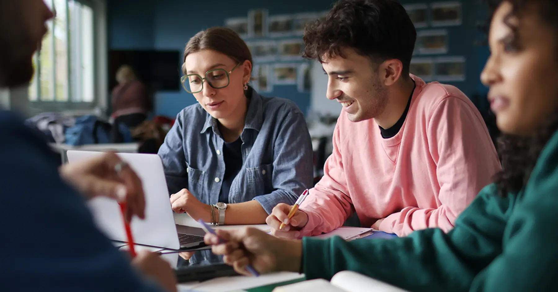 Photo of students at a laptop sharing digital badges they've earned
