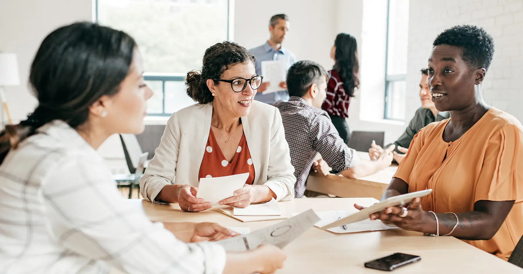 Photo of three faculty members around a table talking about the AI capabilities of Blackboard LMS