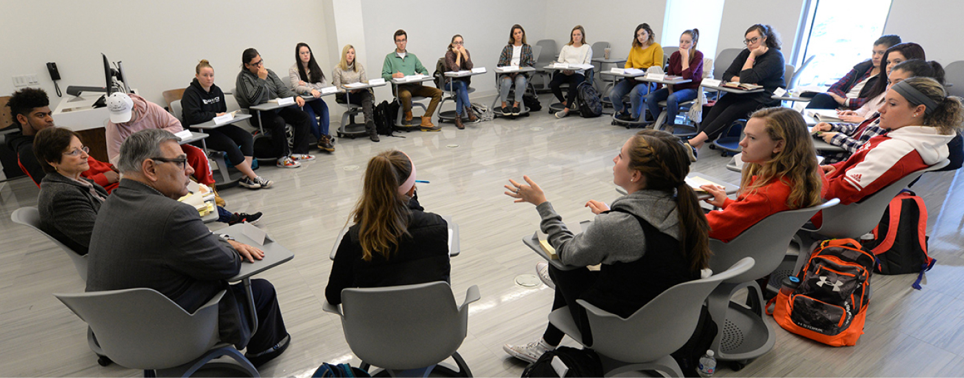 Faculty and students talking in a seated circle
