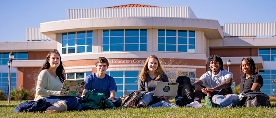 Students sitting on the grass on campus