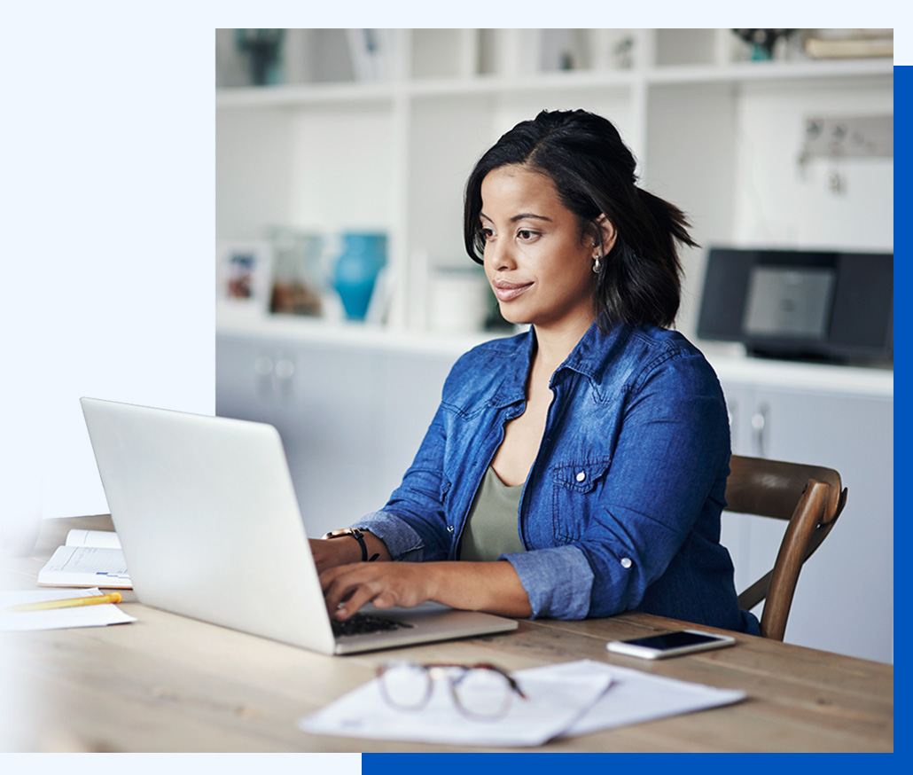 Photo of a woman working at a laptop in a home office